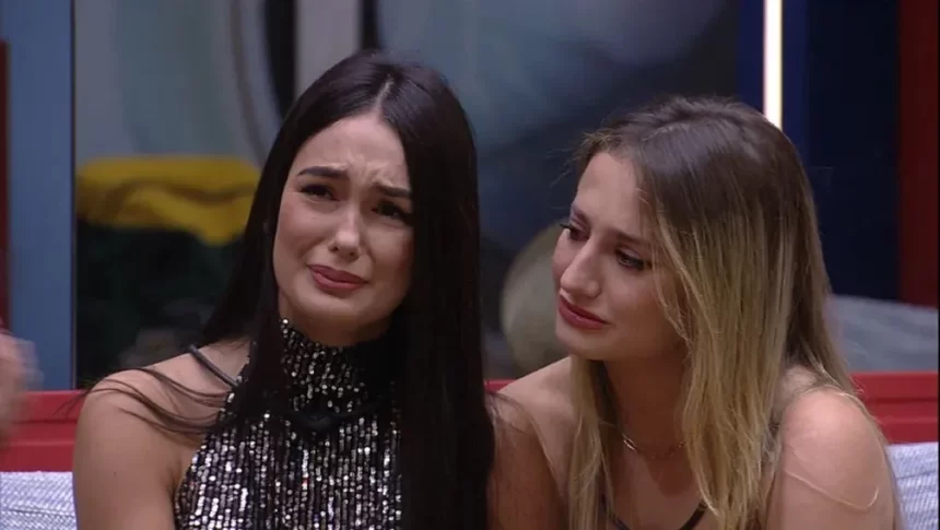 Larissa chorando, sentada, ao lado de Bruna Griphao no sofá do BBB 23