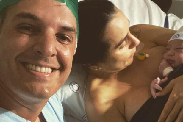 Livia Raick e Leandro Stoliar, posando em foto na cama de hospital, logo após o parto