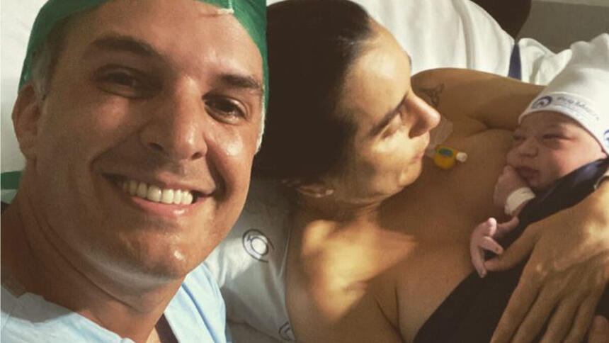 Livia Raick e Leandro Stoliar, posando em foto na cama de hospital, logo após o parto