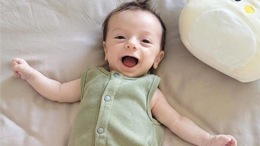 Luca, filho de Claudia Raia, sorrindo em uma foto deitada na cama