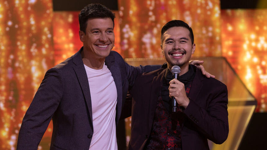 Rodrigo Faro ao lado e abraçado com um participante no palco do episódio de estreia do Canta Comigo 5