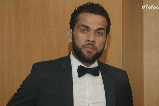 Jogador Daniel Alves de terno preto e com semblante fechado