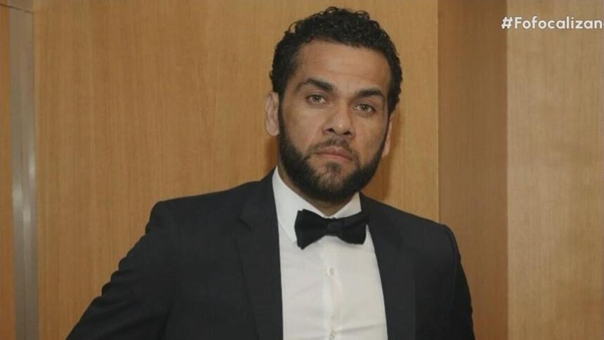 Jogador Daniel Alves de terno preto e com semblante fechado