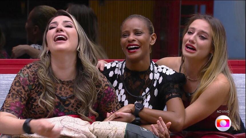 Amanda, Aline Wirley, e Bruna Griphao sentadas no sofá conversando com Tadeu Schimidt e sorrindo por estarem na final do BBB 23