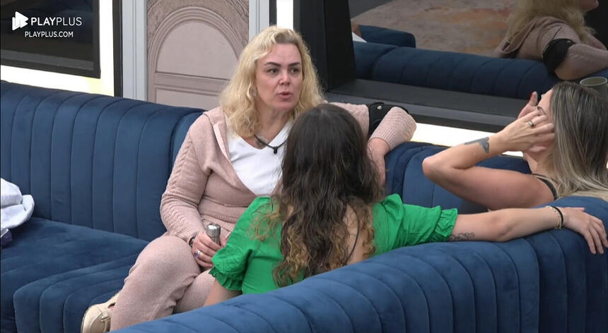 Ana Paula de camisa e calça rosa bebê sentada no sofá ao lado de Faby Monarca e Stephanie