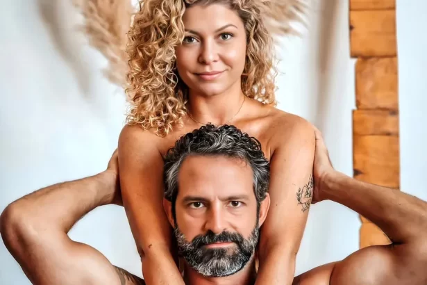 Bárbara Borges com semblante sensual atrás de iran malfitano, sentada, com as mãos nos seios dele