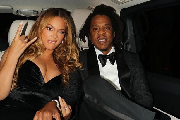 Beyoncé e Jay-Z de preto, sentados no banco do carro volto de evento