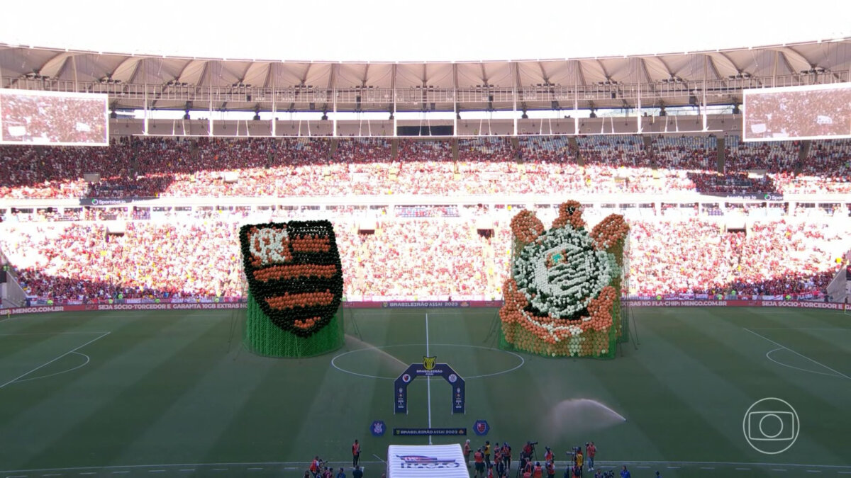 Trecho da transmissão da TV Globo no jogo entre Flamengo e Corinthians, com os logos da equipe no gramado do Maracanã