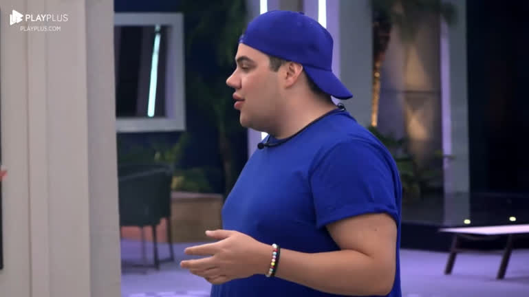 Erick de camisa e chapéu azul conversando em A Grande Conquista