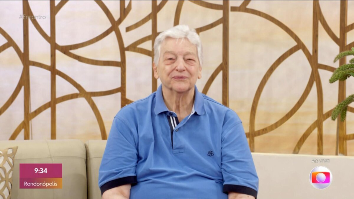 Fúlvio Stefanni de camisa azul sentado no sofá do Encontro