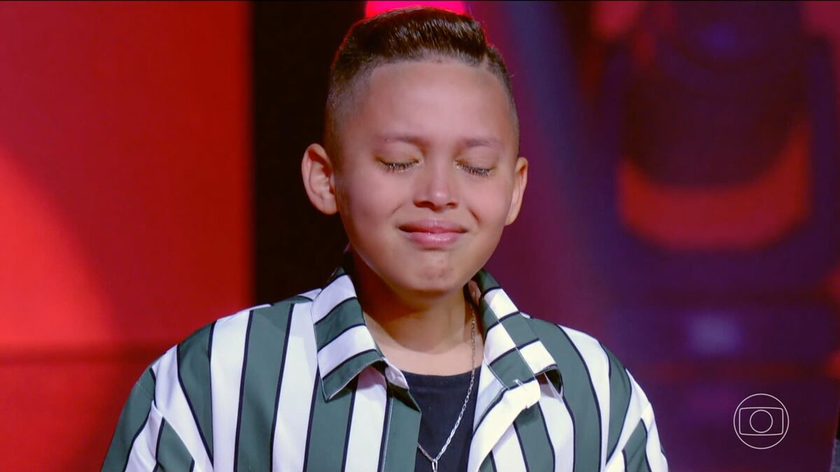 Ben Medeiros chorando no palco do The Voice Kids 8, após ser escolhido por Mumuzinho