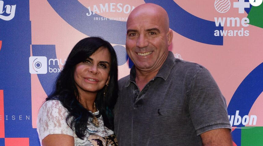 Gretchen e Carlos Marques posando juntos e abraçados nos bastidores de um evento