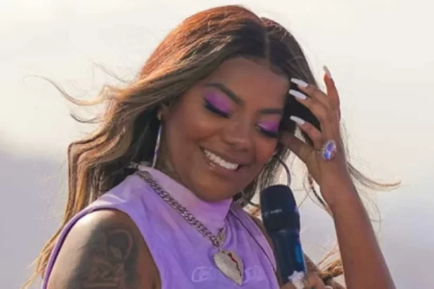 Ludmilla de cabelo solto, sorrindo, com a mão no cabelo