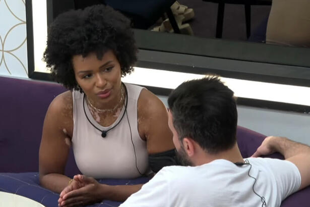 Natália Deodato e Bruno Tálamo conversando na sala de A Grande Conquista