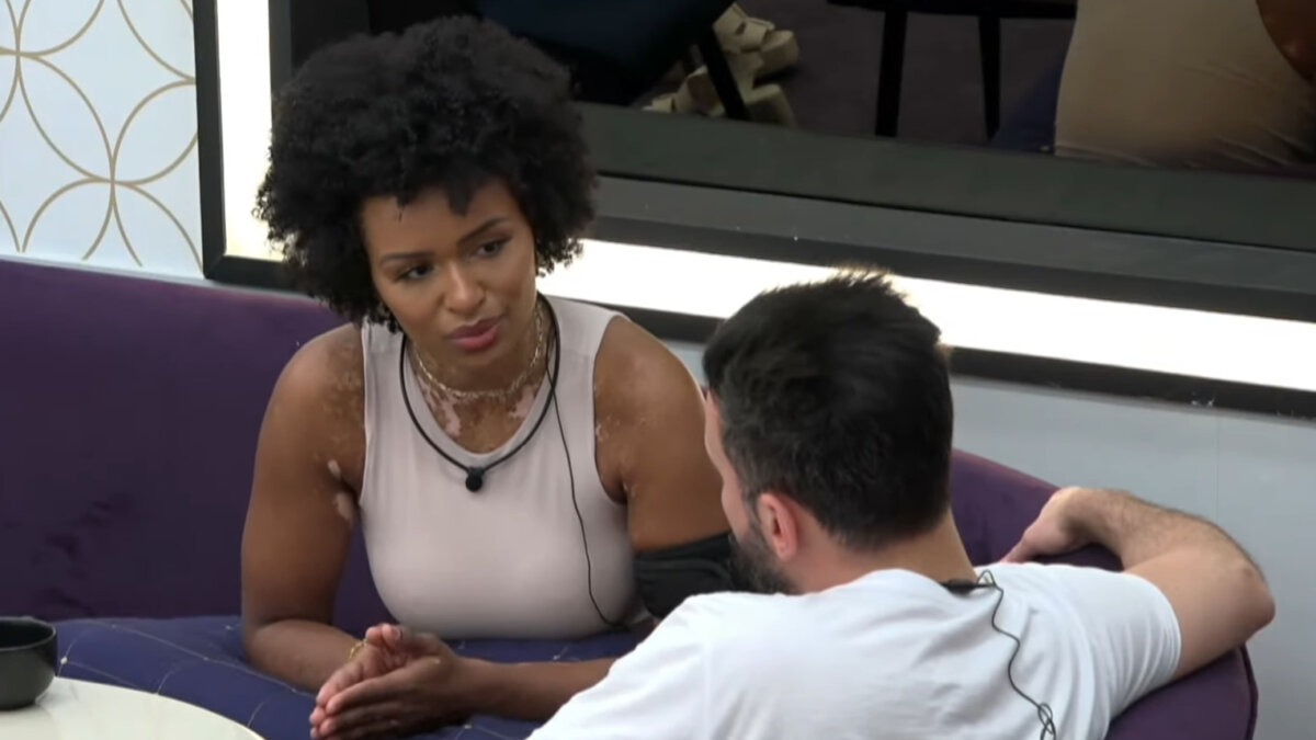 Natália Deodato e Bruno Tálamo conversando na sala de A Grande Conquista