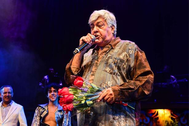 Sidney Magal, com um buque de rosas na mão, em trecho de um show