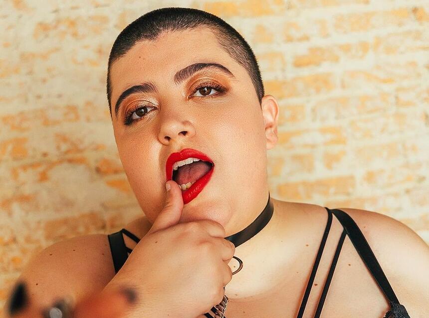 Ana Vilela coloca o dedo na boca com batom vermelho sensualizando em anúncio de perfil no OnlyFans
