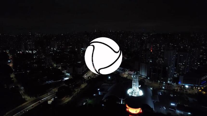 Logo da Record TV próximo a torre de transmissão iluminada com as novas cores