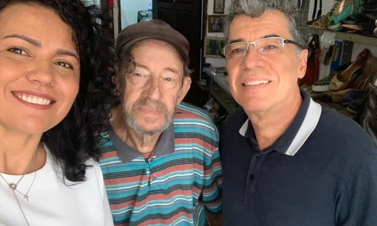 Paulo Betti sorrindo ao lado do irmão e esposa