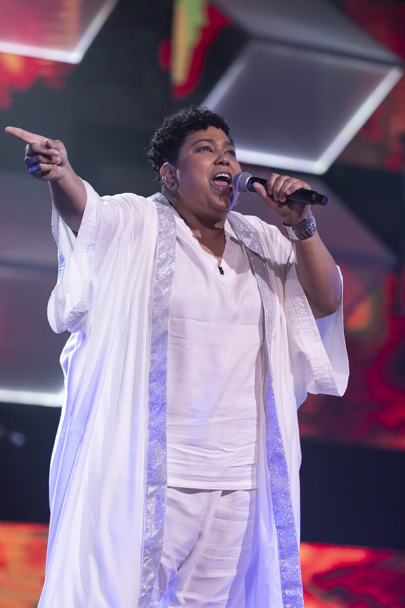 Marcela Martins veste branco enquanto canta no palco do Canta Comigo 5