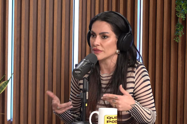 Cleo Pires de camisa listrada, usando fone de ouvido, sentada, durante entrevista