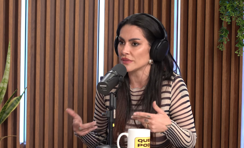 Cleo Pires de camisa listrada, usando fone de ouvido, sentada, durante entrevista