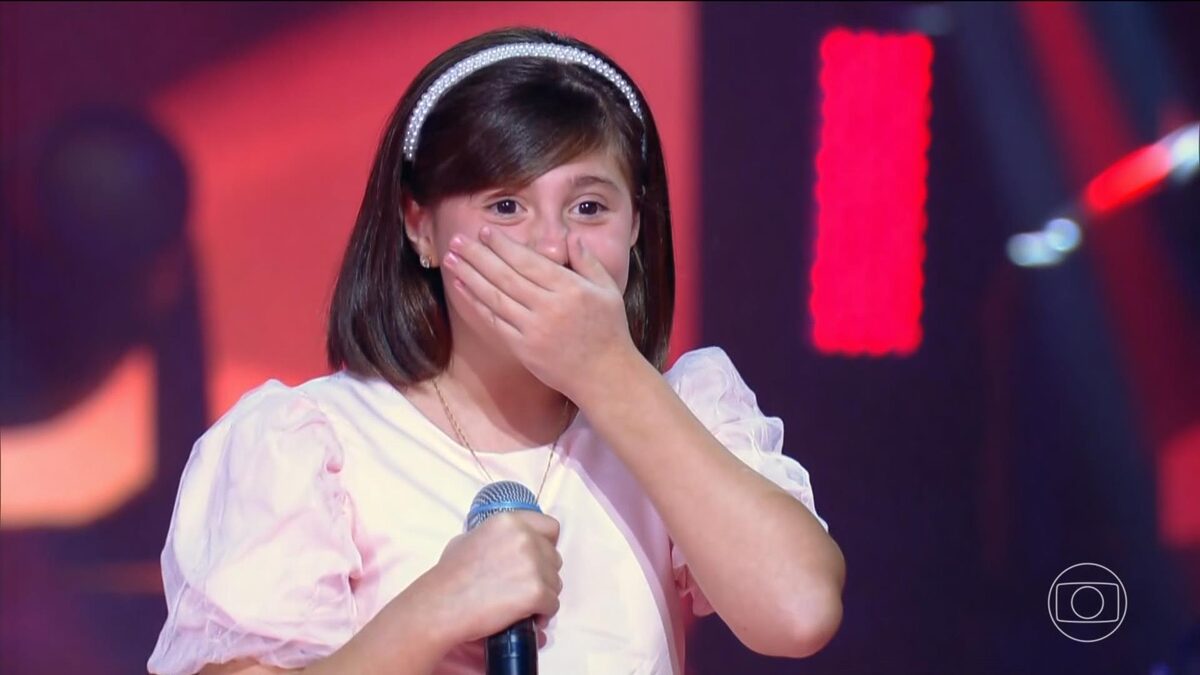 Isa Camargo com a mão na boca sem acreditar que passou para a próxima fase do The Voice Kids 8