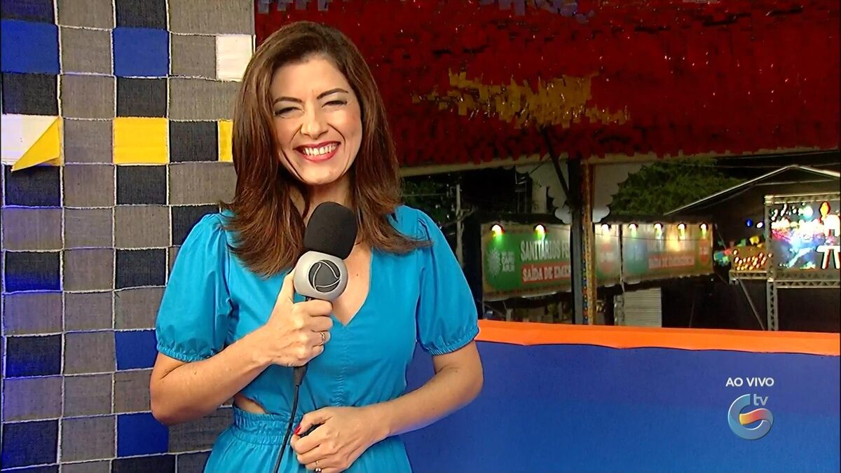 Meiry Lanunce segura o microfone da Record enquanto apresenta o Jornal Guararapes