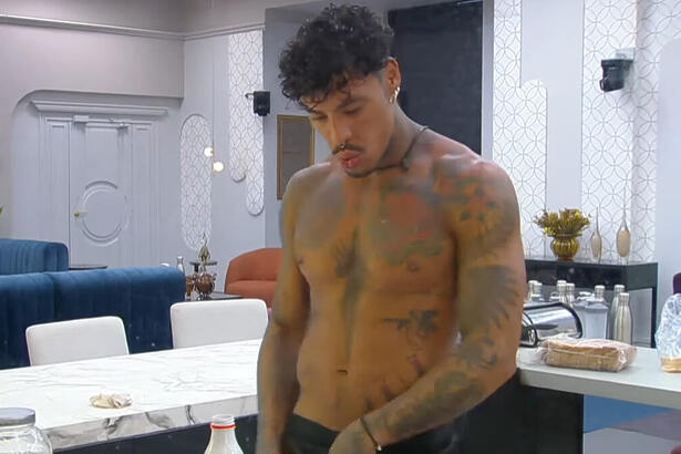 Murilo Dias, sem camisa, na cozinha do A Grande Conquista