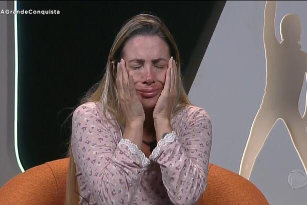 Faby Monarca coloca as mãos no rosto e chora dentro da cabine do A Grande Conquista antes de desistir do programa