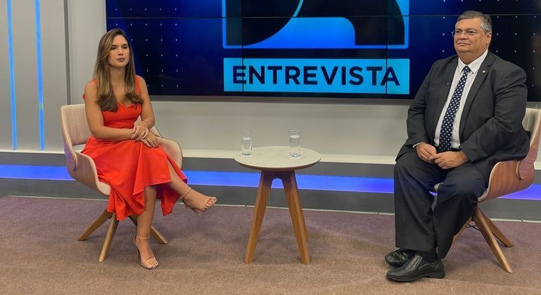 Renata Varandas apresentando o JR Entrevista ao lado do Ministro Flávio Dino