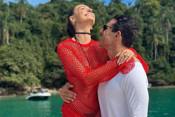 Isis Valverde de vestido vermelho abraçada com Marcus Buaiz