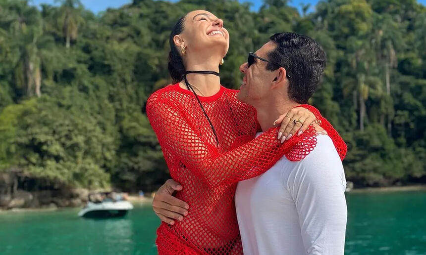 Isis Valverde de vestido vermelho abraçada com Marcus Buaiz