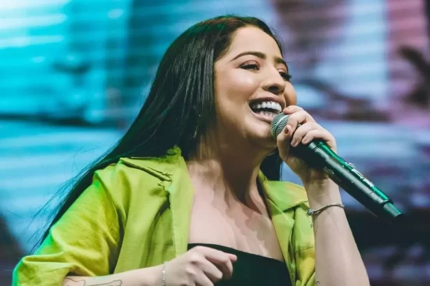 Mari Fernandez sorrindo, segurando o microfone durante show