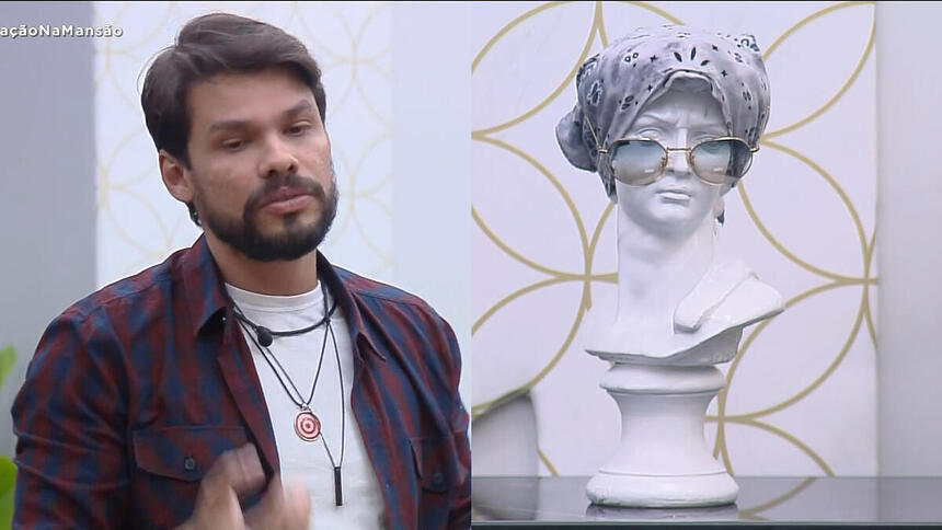 Alexandre Suíta fala sobre o busto estátua do A Grande Conquista que está com um lenço e um óculos escuro