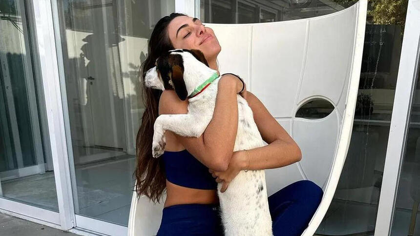 Pétala Barreiros abraçada com o cachorro resgatado