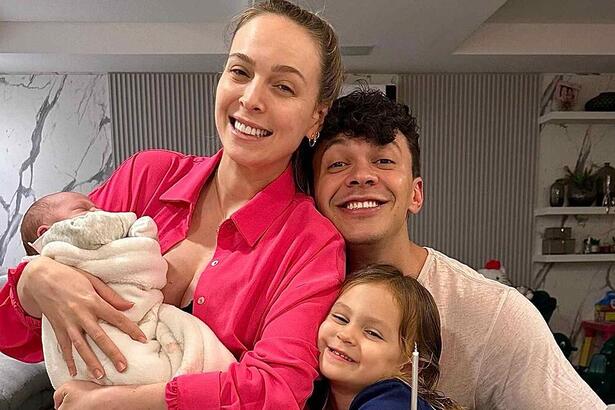 Tata Estanieck e Julio Cocielo sorrindo, abraçados com os filhos durante registro fotográficos em casa