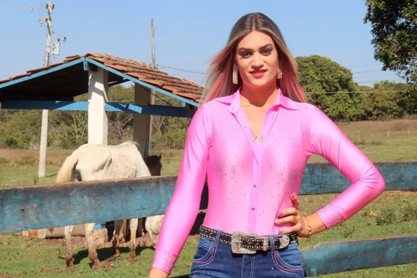 Alessandra Aparecida, posa em frente a uma fazenda. Mulher trans foi eleita rainha de Rodeio