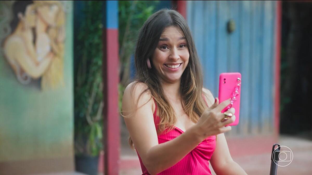 Berenice em cena de Terra e Paixão segurando o telefone que filma Luigi enquanto grita Attenzione Pickpocket