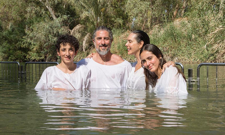 Famíla de Marcos Mion de camisa branca, sorrindo, durante batismo