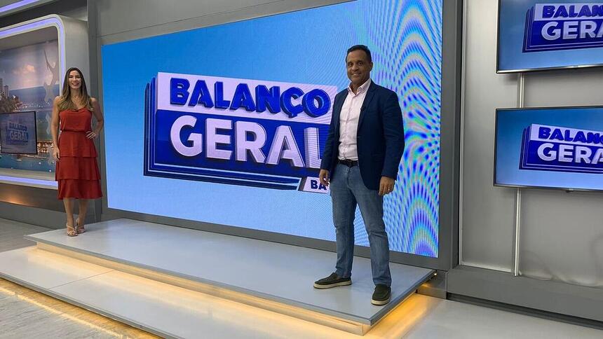 Jessica Smetak e José Eduardo Bocam em frente ao telão do Balanço Geral BA, líder de audiência na Record TV Itapoan