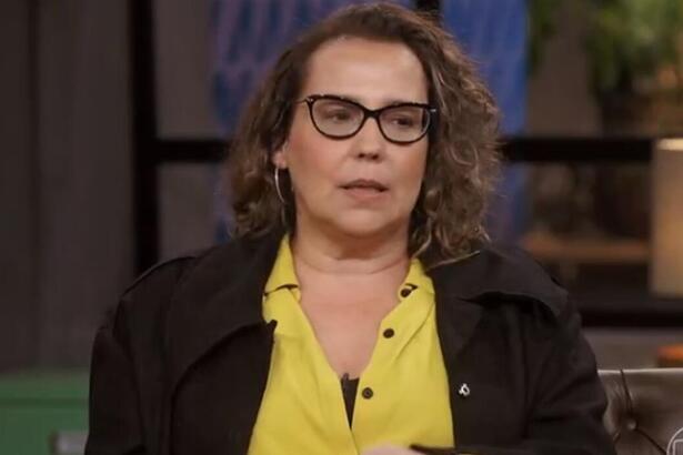 Ana Beatriz Nogueira de camisa social amarela e blazer preto, sentada em frente a Pedro Bial durante gravação de entrevista