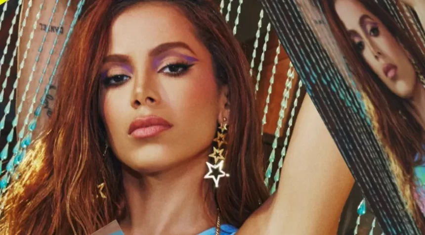 Anitta de cabelo solto, maquiagem azulada, com top azul para gravação de videoclipe