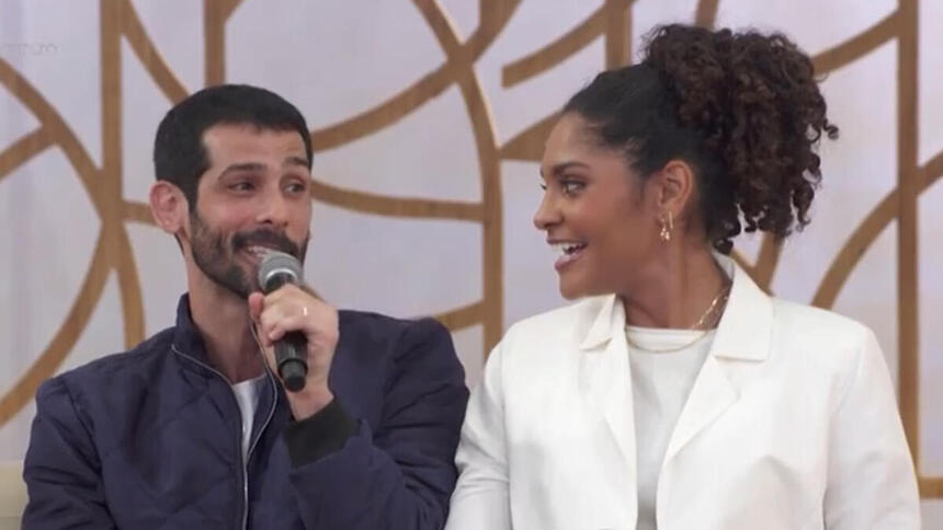 Barbara Reis e Raphael Najan sentados no sofá, durante participação no Encontro