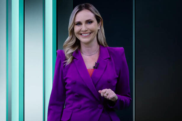 Caroline Nequirito, com um blazer roxo, apresentando o Leitura Dinâmica na RedeTV!