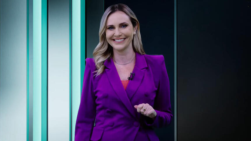 Caroline Nequirito, com um blazer roxo, apresentando o Leitura Dinâmica na RedeTV!