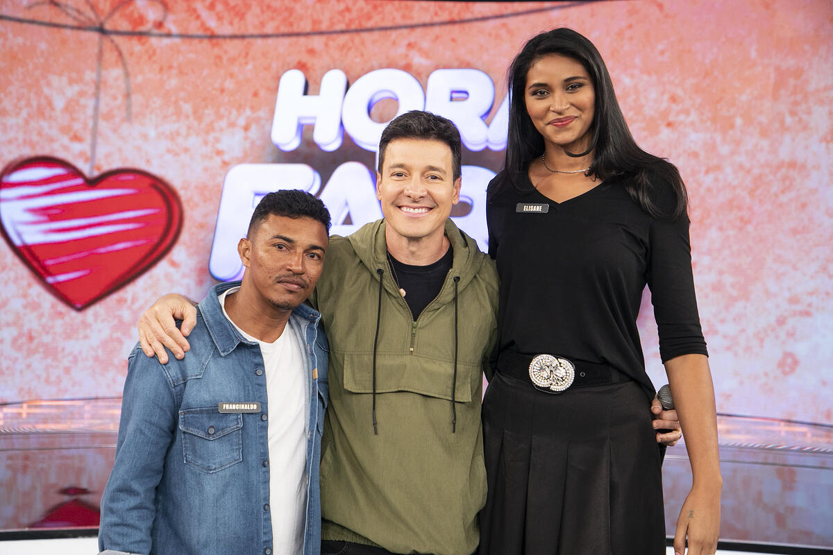 Casal Elisane e Francinaldo posando ao lado de Rodrigo Faro no palco do Hora do Faro