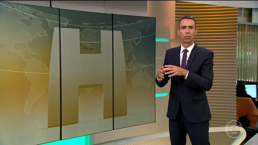 Cesar Tralli em frente ao telão, no estúdio do Jornal Hoje