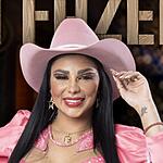 Jenny Miranda com conjunto e chapéu rosa levantando o braço esquerdo na divulgação de A Fazenda 15