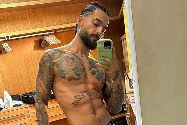 Maluma posando sem camisa e de cueca em frente a um espelho